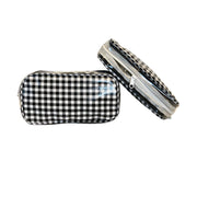 Front view: Two small travel cases, white and black checkered pattern.