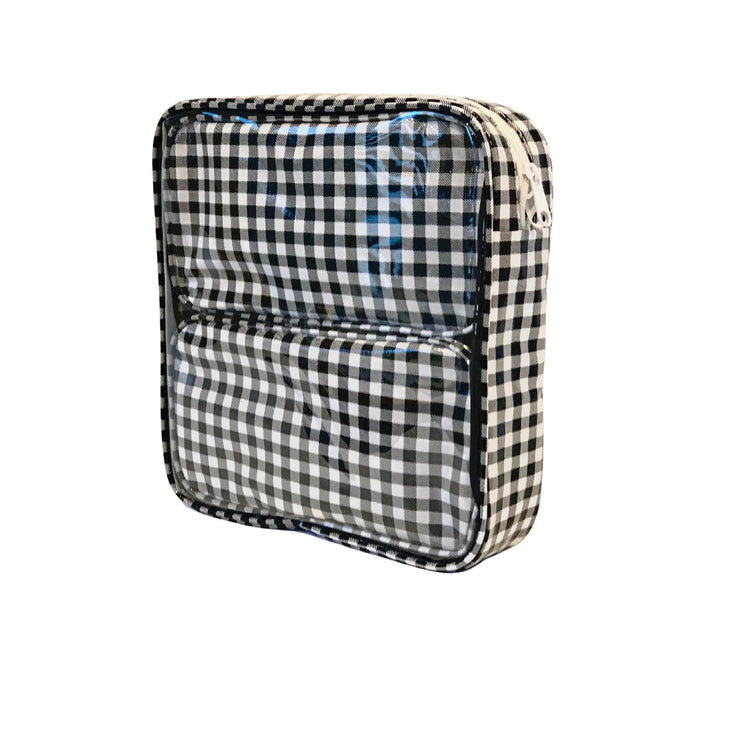 Side view: Two small travel cases, white and black checkered pattern, fitting inside the large case.