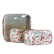 Front view: One large case and two small travel cases, multi-colored cherry blossom print on gray background.