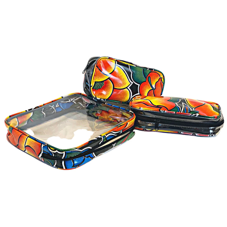 Above view: One large and two small travel cases, multi-colored floral print on black background.