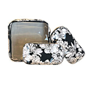 Front view:  One large case and two small travel cases, white floral print on black background.