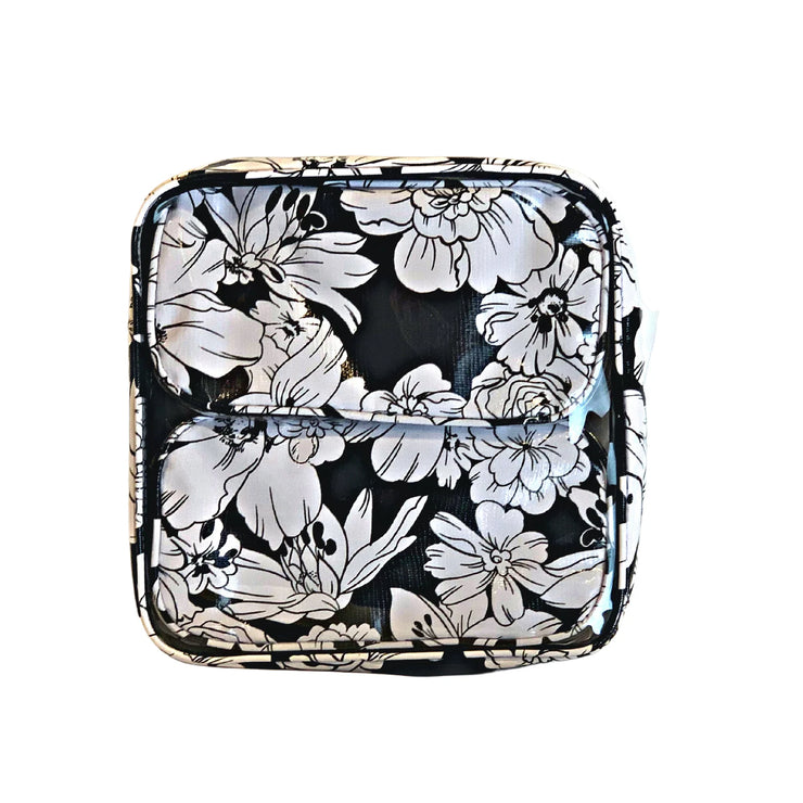 Front view:  Two small travel cases, white floral print on black background, fitting inside the large case.