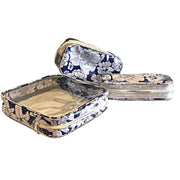 Above view:  One large case and two small travel cases, white floral print on blue background.