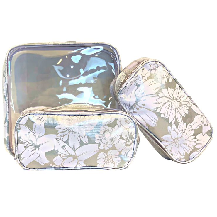 Front view: One large case and two small travel cases, white floral print on silver background.