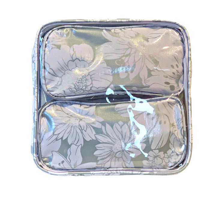 Front view:  Two small travel cases, white floral print on silver background, fitting inside the large case.