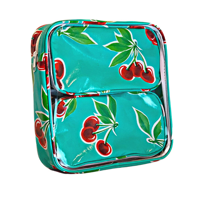 Front view: Two small travel cases, cherry print on green background, fitting inside the large case.