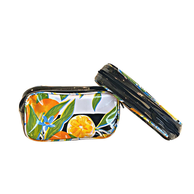 Front view: Two small travel cases, multi-colored orange fruit and blossom print on black background.