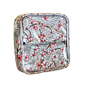 Side view: Two small travel cases, multi-colored cherry blossom print on gray background, fitting inside the large case.