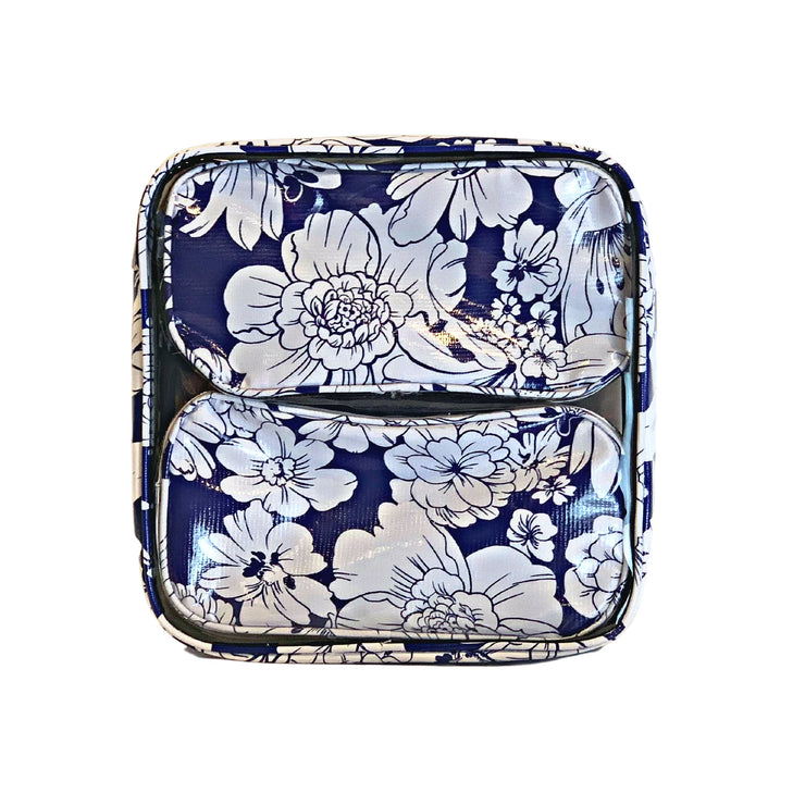 Front view:  Two small travel cases, white floral print on blue background, fitting inside the large case.