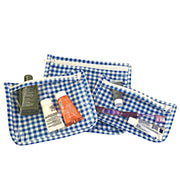 Above view: Small, medium and large slim travel bags, white zippers and white and blue checkered pattern, showing travel items through transparent front.