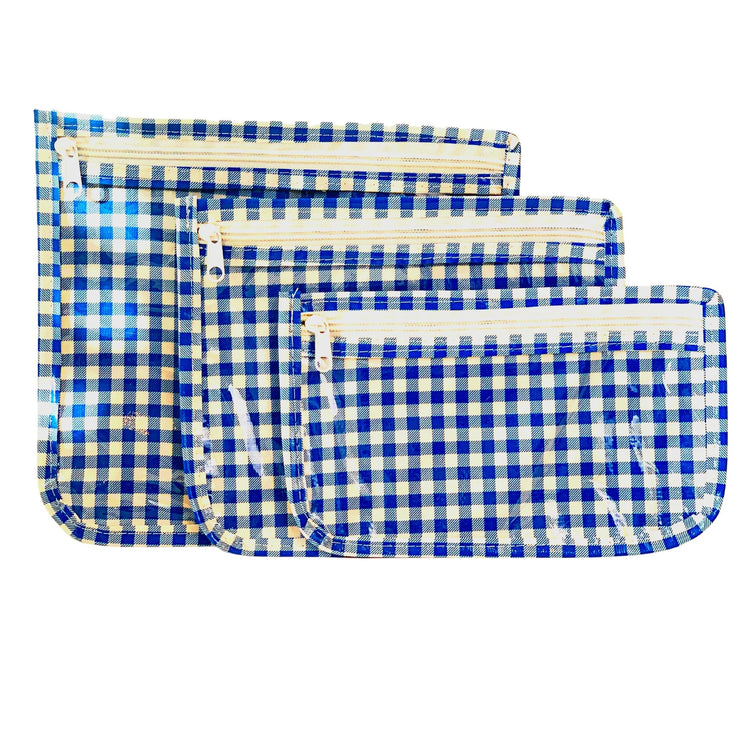 Front view: Small, medium and large slim travel bags, white zippers and white and blue checkered pattern.
