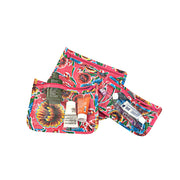 Above view: Small, medium and large slim travel bags, pink zippers and multi-colored floral print on pink background, showing travel items through transparent front.
