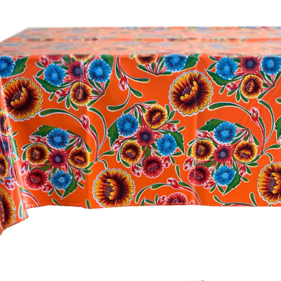 Side view: Multi-colored floral print on terracotta background tablecloth covering table. 