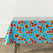 Side view:  Multi-colored floral print on light blue background tablecloth covering table.