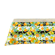 Side view: Orange fruit print on black and white background tablecloth covering table.