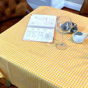 Above view: Yellow and white checkered pattern tablecloth covering table with open notebook displayed.