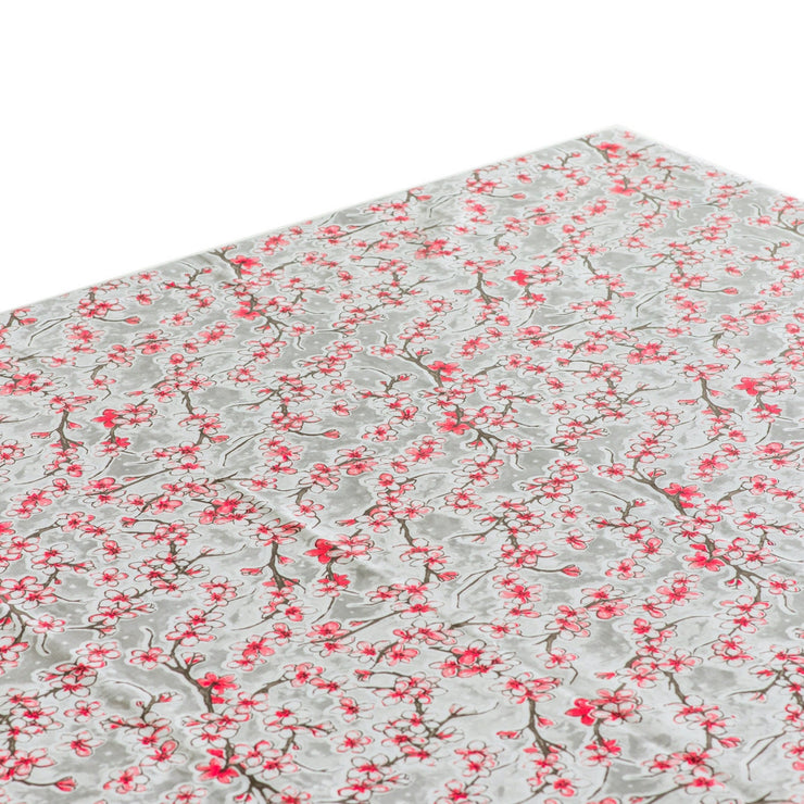 Above view: Cherry blossom print on gray background tablecloth covering table.