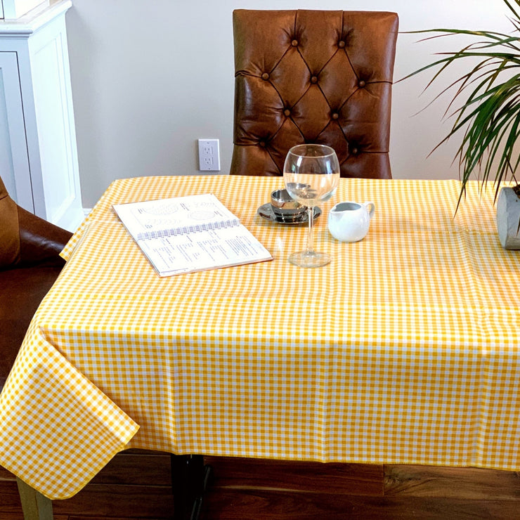 Above view: Yellow and white checkered pattern tablecloth covering table, open notebook displayed.