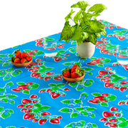 Above view: Strawberry print on blue background tablecloth covering table with potted plant centerpiece.