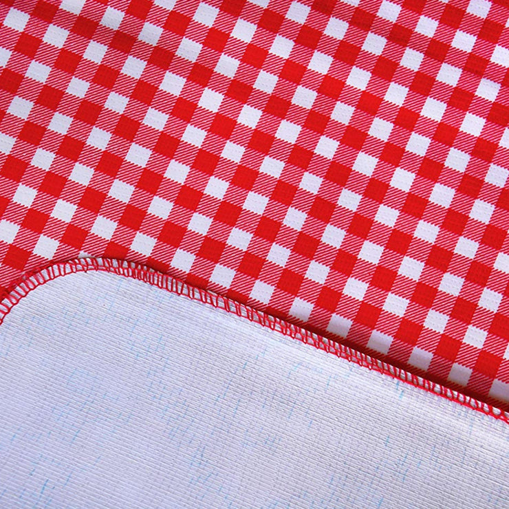 Close up: Red and white checkered pattern tablecloth, white underside folded up to show contrast.