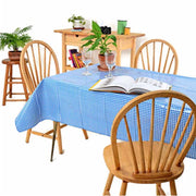 Side view: Blue and white checkered pattern tablecloth covering table, open book displayed with potted plant centerpiece. 