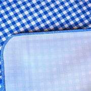 Close up:  Blue and white checkered pattern tablecloth, white underside folded up to show contrast. 