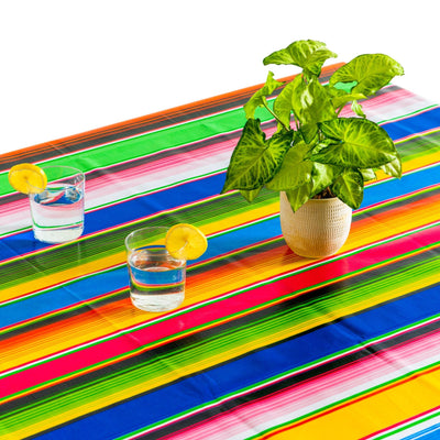 Above view: Multi-colored vertical striped patterned tablecloth covering table, with potted plant centerpiece.