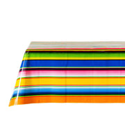 Side view: Multi-colored vertical striped patterned tablecloth covering table.