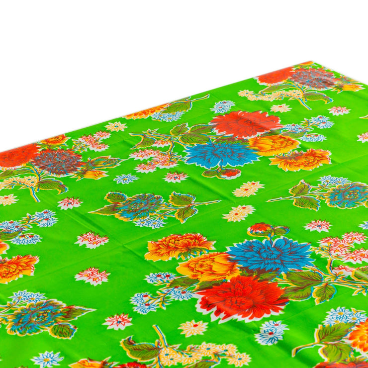 Above view: Multi-colored floral print on green background tablecloth, covering table.