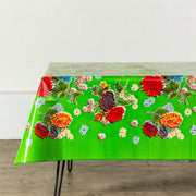 Side view: Multi-colored floral print on green background tablecloth, covering table.