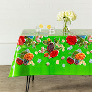 Side view: Multi-colored floral print on green background tablecloth, covering table, with flower centerpiece.