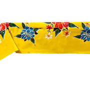 Side view: Multi-colored hibiscus print on yellow background tablecloth covering table.