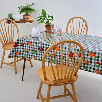 Above view:  Fruit print on green and white checkered background tablecloth covering table, with potted plant centerpiece.