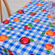 Above view: Fruit print on blue and white checkered background tablecloth covering table.