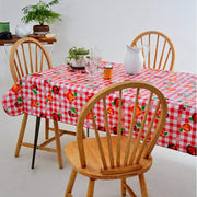 Side view:  Fruit print on red and white checkered background, with potted plant as centerpiece.