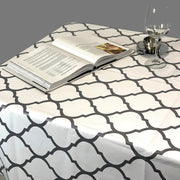 Above view: Gray and white damascus print tablecloth covering table, with open book displayed.