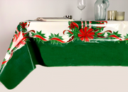 Side view: Green ribbons with poinsettia edging on white background tablecloth, open book displayed.