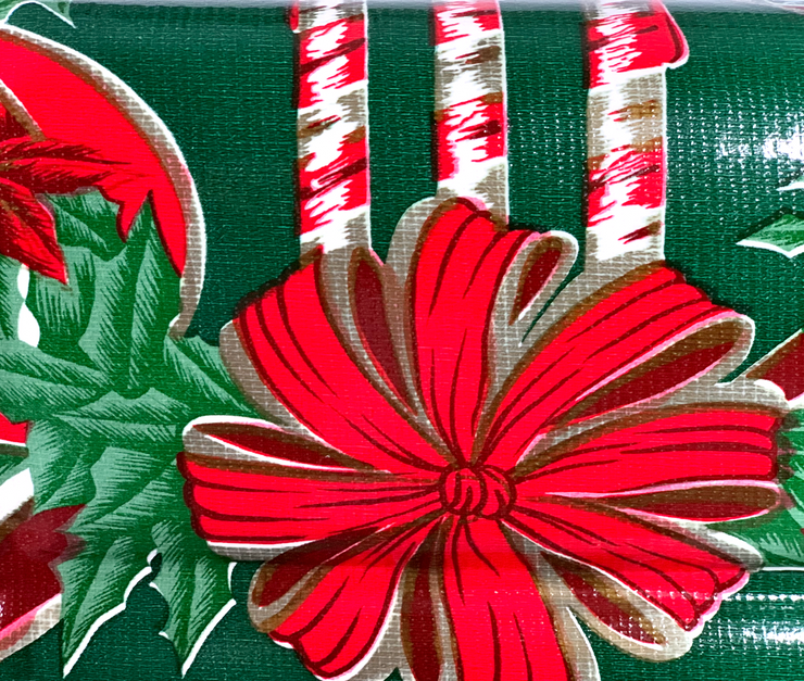 Close up: Green ribbons with poinsettia edging on white background tablecloth.