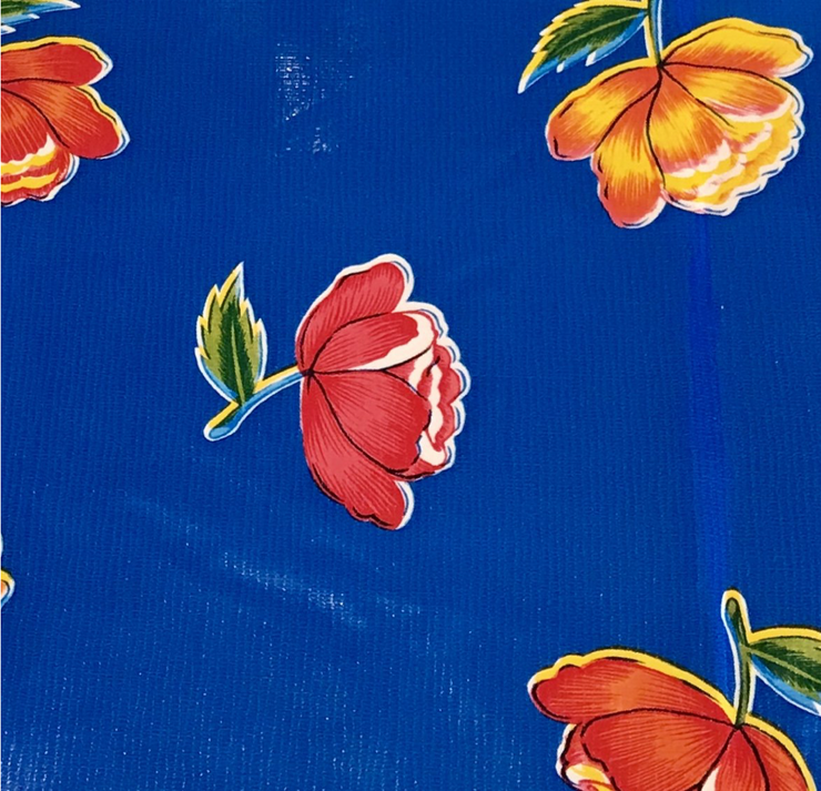 Close up: Multi-colored flower print on blue background tablecloth.