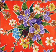 Close up: Multi-colored floral print on orange background tablecloth.