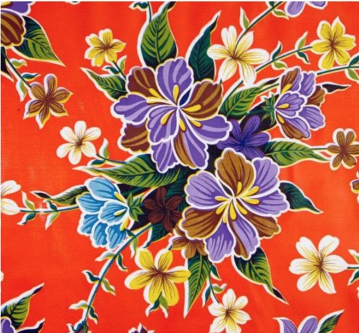 Close up: Multi-colored floral print on orange background tablecloth.