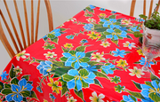Above view: Multi-colored floral print on red background tablecloth, with potted plant centerpiece.