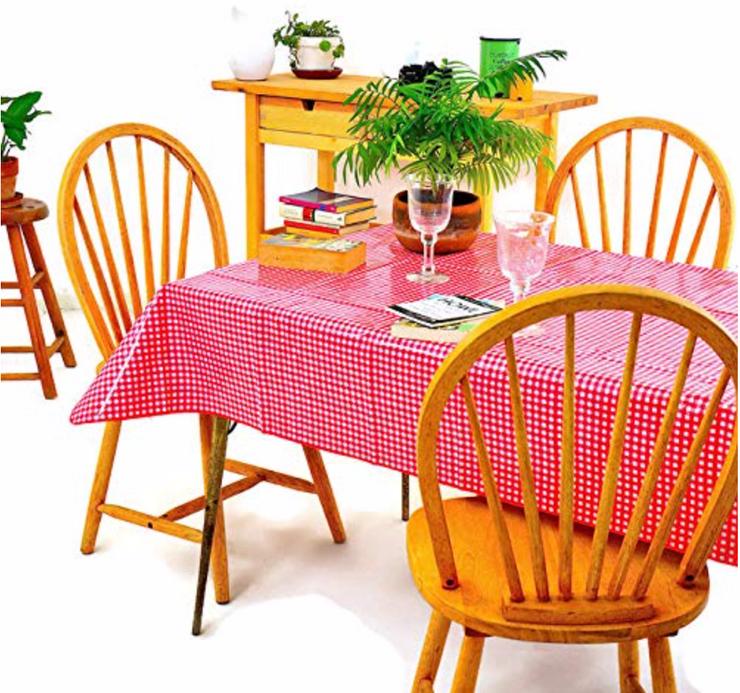 Angle view: Red and white checkered pattern tablecloth, books displayed and potted plant centerpiece.
