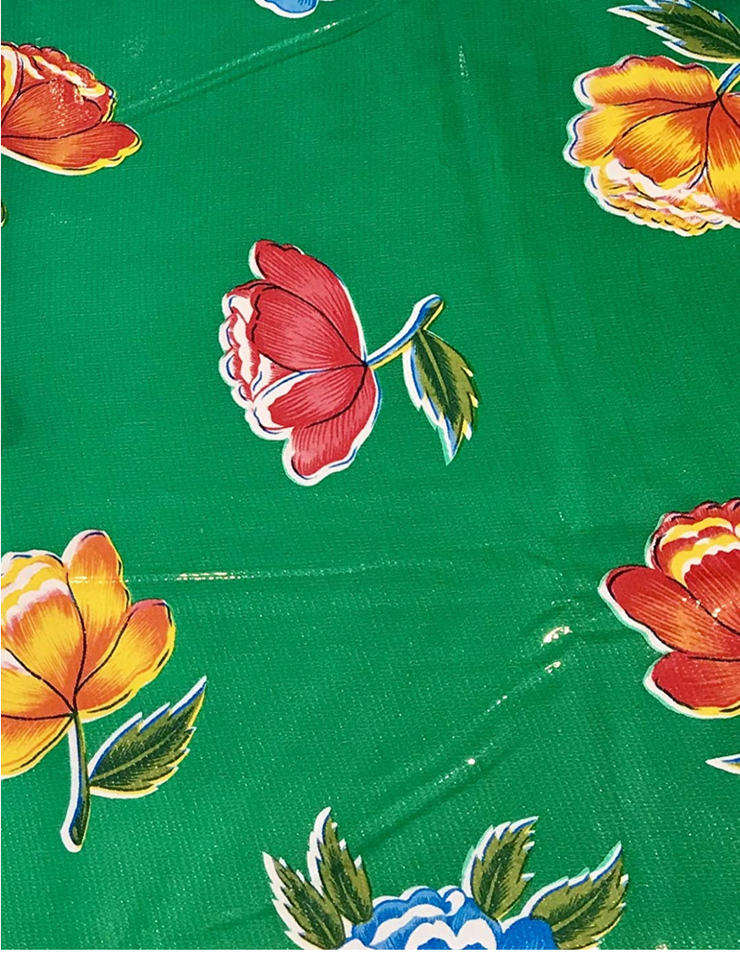 Close up: Multi-colored flower print on green background tablecloth.