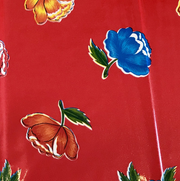 Close up: Multi-colored flower print on red background tablecloth.