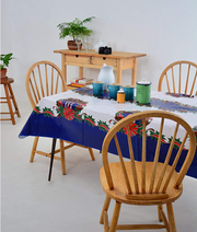 Angle view: Red ribbons with poinsettia edging on white and blue striped background tablecloth, jars centerpiece.