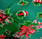 Close up: Multi-colored Christmas holiday print on green background tablecloth.
