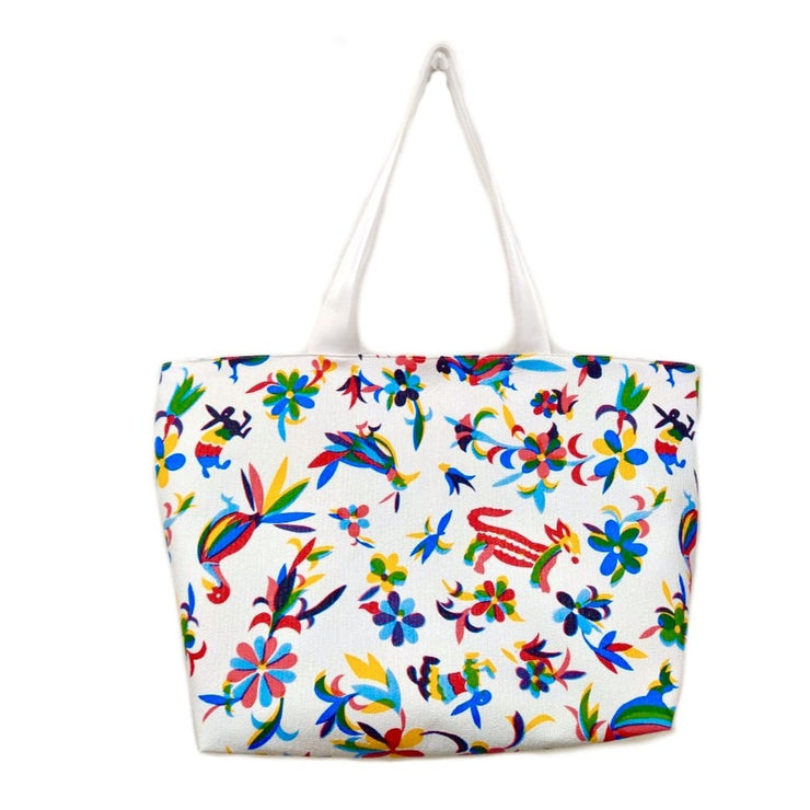 Front view: Multi-colored animal/floral print on white background tote with white handles.