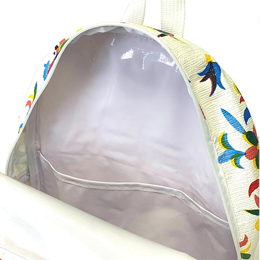 Top view: Otomi backpack with multi-colored flower/animal print on white background, opened showing white interior with pocket.