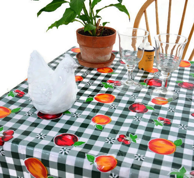 Angle view: Multi-colored fruit print on green and white checkered pattern background tablecloth, with potted plant centerpiece.